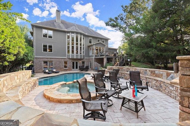 979 Pathview Ct, Dacula, GA 30019 - view of swimming pool with stairway, a patio, a deck, a pool with connected hot tub, and french doors