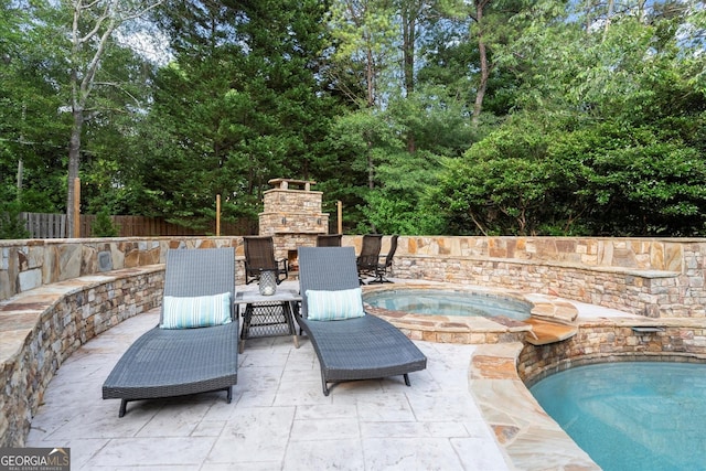 979 Pathview Ct, Dacula, GA 30019 - view of patio / terrace featuring an outdoor stone fireplace, an in-ground hot tub, and view of wooded area