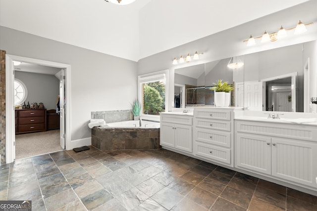 979 Pathview Ct, Dacula, GA 30019 - full bathroom with double vanity, stone tile floors, a bath, baseboards, and a tile shower