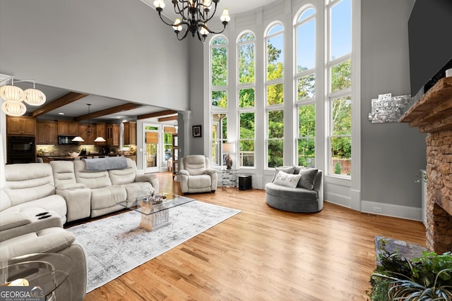 979 Pathview Ct, Dacula, GA 30019 - living room with a high ceiling, plenty of natural light, a chandelier, wood finished floors, and beam ceiling