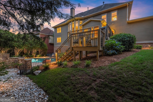 979 Pathview Ct, Dacula, GA 30019 - back of property at dusk featuring stairs, a wooden deck, and a chimney