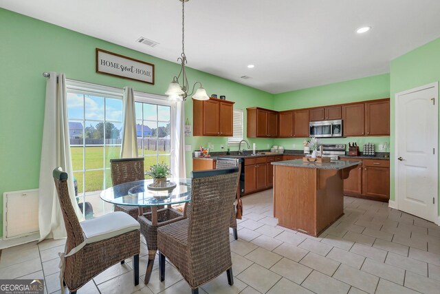 17 Sagefield Dr, Ellabell, GA 31308 - kitchen with stainless steel appliances, a center island, dark countertops, hanging light fixtures, and recessed lighting