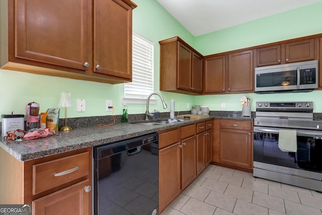 17 Sagefield Dr, Ellabell, GA 31308 - kitchen with appliances with stainless steel finishes, a sink, light tile patterned floors, and brown cabinetry
