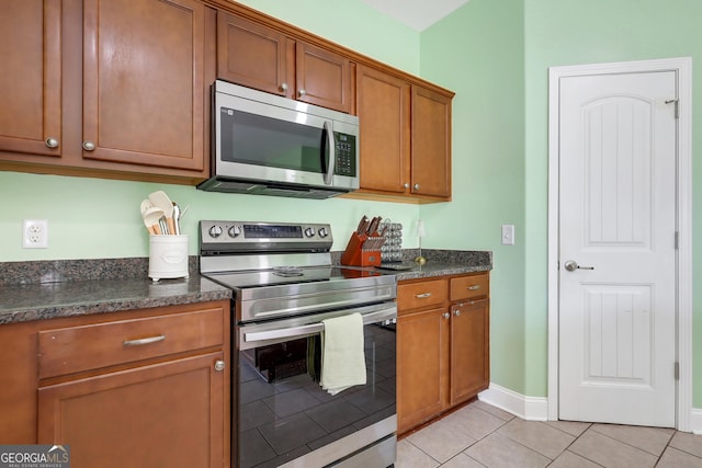 17 Sagefield Dr, Ellabell, GA 31308 - kitchen with stainless steel appliances, brown cabinetry, light tile patterned floors, and baseboards