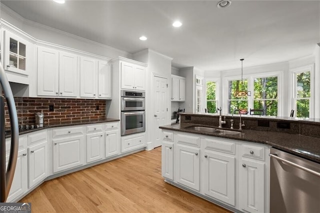 1860 Hill Chase, Alpharetta, GA 30022 - kitchen with stainless steel appliances, a sink, white cabinets, light wood finished floors, and tasteful backsplash
