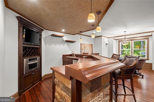 1860 Hill Chase, Alpharetta, GA 30022 - indoor wet bar featuring stainless steel appliances, crown molding, dark wood-style flooring, baseboards, and pendant lighting