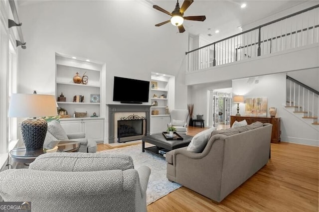 1860 Hill Chase, Alpharetta, GA 30022 - living area featuring light wood-style floors, a ceiling fan, a fireplace with flush hearth, stairway, and built in features