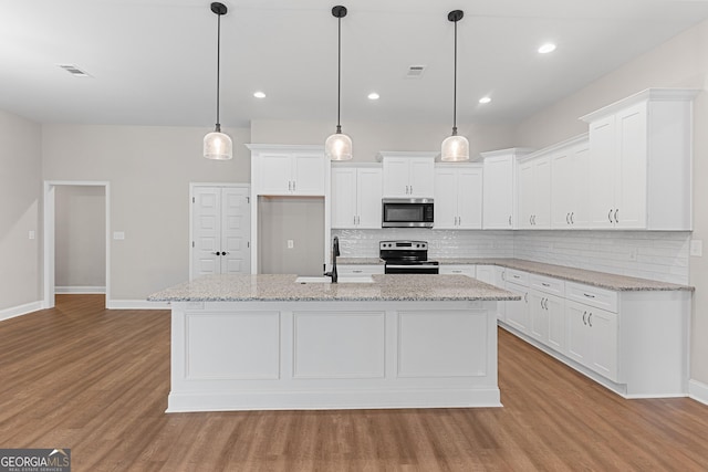 488 Nandina Ct, Warner Robins, GA 31088 - kitchen featuring appliances with stainless steel finishes, light wood finished floors, decorative backsplash, white cabinetry, and recessed lighting