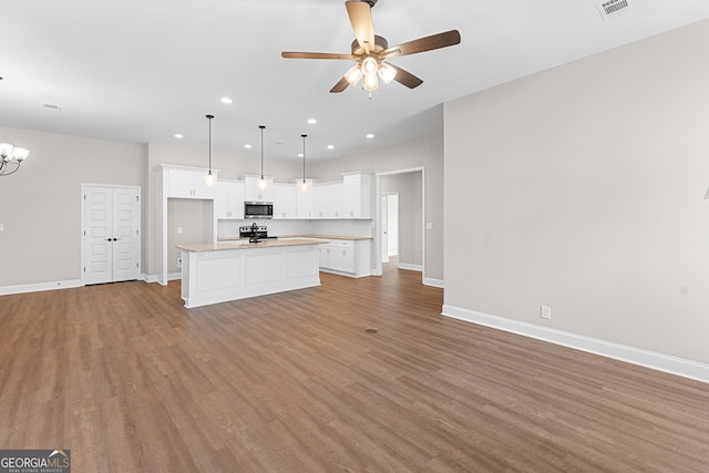 488 Nandina Ct, Warner Robins, GA 31088 - unfurnished living room featuring a ceiling fan, recessed lighting, wood finished floors, and a chandelier