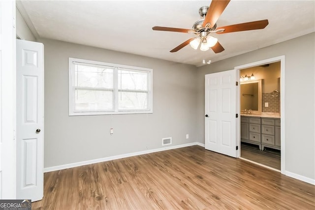 5798 Salem Rd, Covington, GA 30016 - unfurnished bedroom featuring wood finished floors, baseboards, ensuite bathroom, and ceiling fan