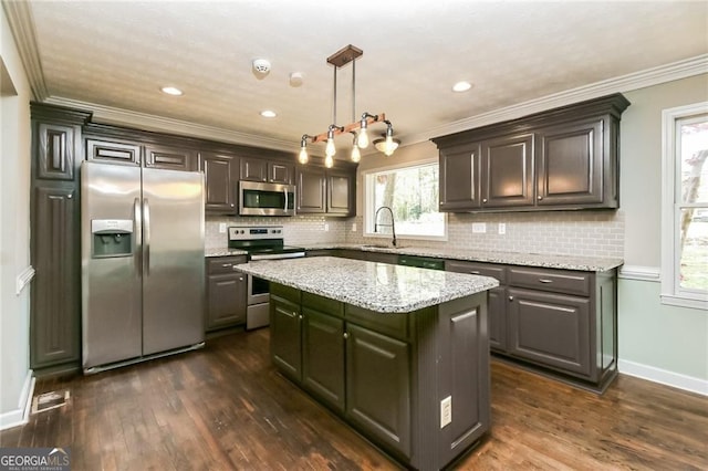 5798 Salem Rd, Covington, GA 30016 - kitchen featuring stainless steel appliances, a sink, dark wood-style flooring, a center island, and crown molding