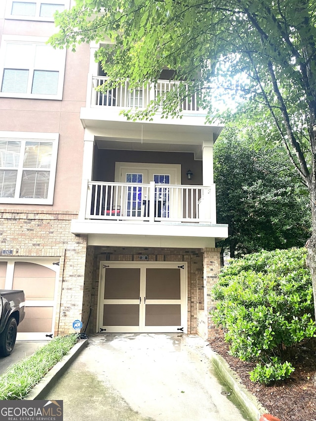 241 Perimeter Walk, Atlanta, GA 30338 - view of front of home with a balcony, a garage, driveway, and brick siding