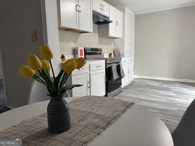 212 W Quilly St, Griffin, GA 30223 - kitchen featuring stainless steel electric range, under cabinet range hood, white cabinetry, and light wood-style floors
