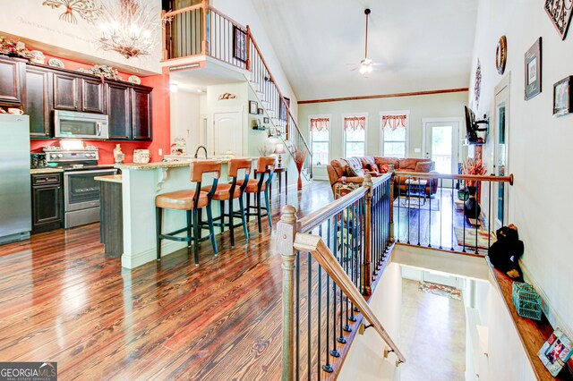 496 Cedar Valley Dr, Wedowee, AL 36278 - kitchen with appliances with stainless steel finishes, high vaulted ceiling, a breakfast bar, ceiling fan, and wood finished floors