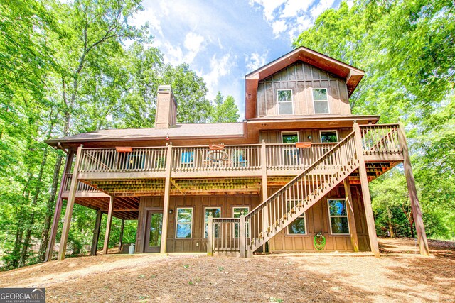 496 Cedar Valley Dr, Wedowee, AL 36278 - back of property featuring a wooden deck, stairway, board and batten siding, and a chimney