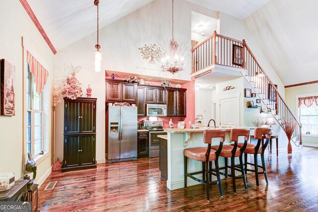 496 Cedar Valley Dr, Wedowee, AL 36278 - kitchen featuring stainless steel appliances, dark wood-style flooring, a breakfast bar area, a kitchen island with sink, and high vaulted ceiling