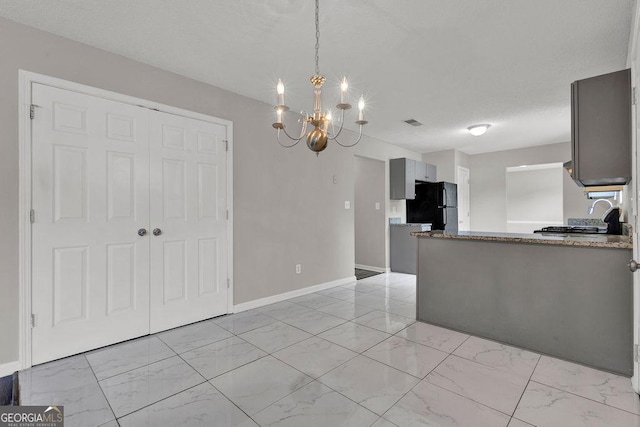 3885 Riverview Chase Blf, Ellenwood, GA 30294 - kitchen featuring freestanding refrigerator, light marble finish flooring, a chandelier, and a sink