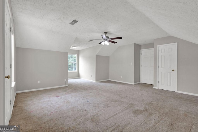 3885 Riverview Chase Blf, Ellenwood, GA 30294 - additional living space featuring lofted ceiling, ceiling fan, a textured ceiling, carpet flooring, and baseboards