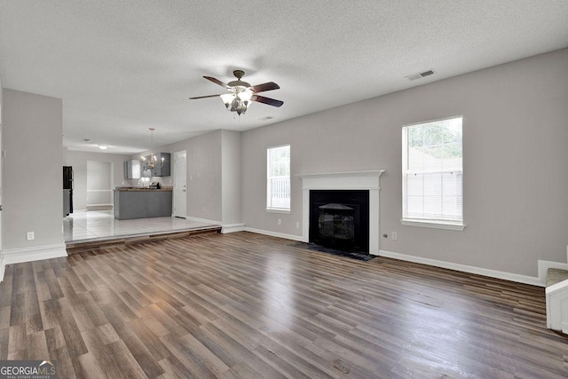 3885 Riverview Chase Blf, Ellenwood, GA 30294 - unfurnished living room featuring a ceiling fan, baseboards, wood finished floors, a fireplace with flush hearth, and a textured ceiling