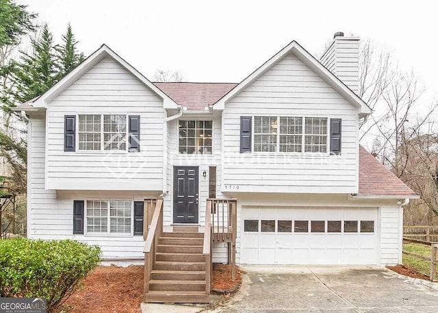 5710 Cardigan Trce, Sugar Hill, GA 30518 - split foyer home with an attached garage, driveway, a chimney, and roof with shingles