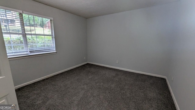 5710 Cardigan Trce, Sugar Hill, GA 30518 - empty room with dark carpet, baseboards, and a textured ceiling