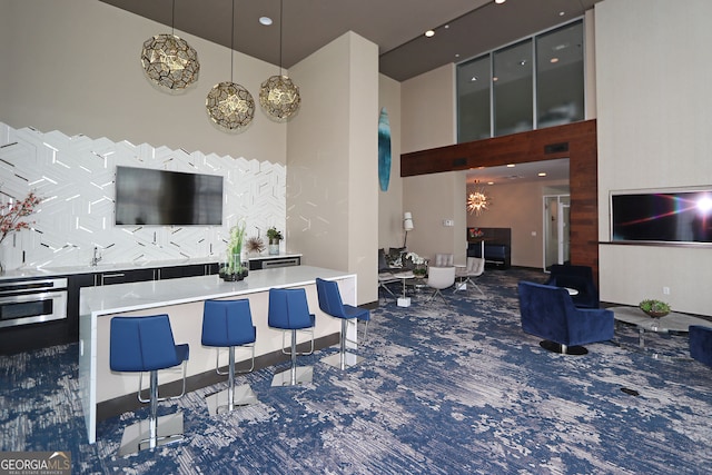4561 Olde Perimeter Way Unit 608, Dunwoody, GA 30346 - bar area with a towering ceiling, carpet flooring, decorative backsplash, stainless steel oven, and recessed lighting
