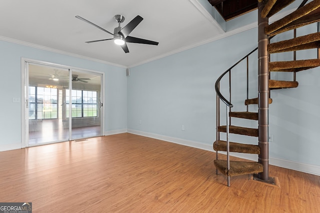 202 Kimberly Rd, Warner Robins, GA 31088 - unfurnished living room with wood finished floors, a ceiling fan, crown molding, stairs, and baseboards