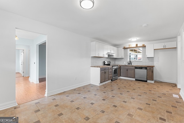 202 Kimberly Rd, Warner Robins, GA 31088 - kitchen with appliances with stainless steel finishes, white cabinets, tasteful backsplash, a sink, and baseboards