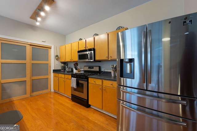 115 W Peachtree Pl NW Unit 301, Atlanta, GA 30313 - kitchen with appliances with stainless steel finishes, dark countertops, and light wood-style flooring