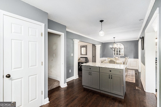 1112 Sutton Dr, Mcdonough, GA 30252 - kitchen with gray cabinets, decorative columns, dark wood-style flooring, decorative light fixtures, and a chandelier