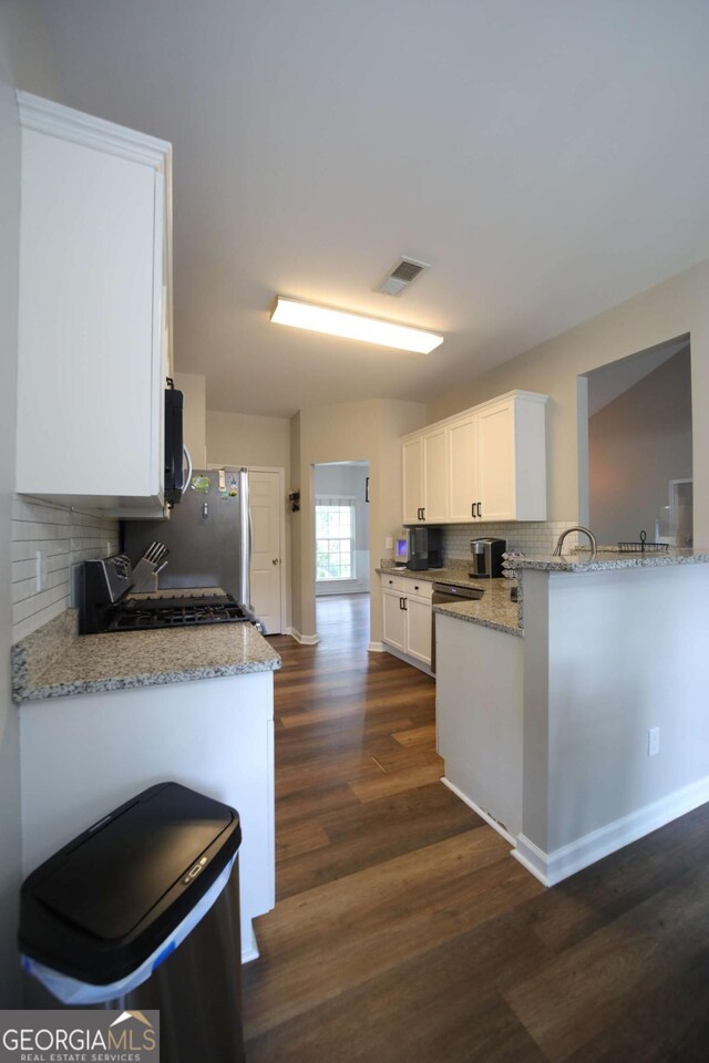 262 Devynwood Ln, Dallas, GA 30157 - kitchen featuring appliances with stainless steel finishes, decorative backsplash, dark wood finished floors, white cabinetry, and light stone countertops