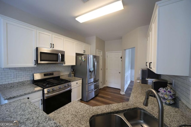 262 Devynwood Ln, Dallas, GA 30157 - kitchen featuring appliances with stainless steel finishes, dark wood-style flooring, white cabinets, light stone countertops, and backsplash