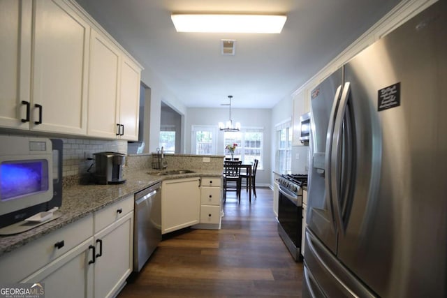 262 Devynwood Ln, Dallas, GA 30157 - kitchen featuring appliances with stainless steel finishes, dark wood finished floors, white cabinetry, a peninsula, and tasteful backsplash