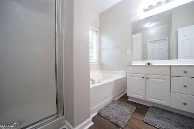 262 Devynwood Ln, Dallas, GA 30157 - full bath featuring wood finished floors, vanity, a shower stall, and a garden tub