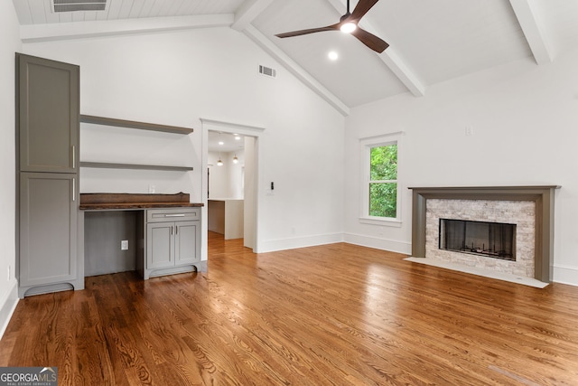 1036 Dell Ave SE, Smyrna, GA 30080 - unfurnished living room featuring beam ceiling, a ceiling fan, wood finished floors, a fireplace, and high vaulted ceiling