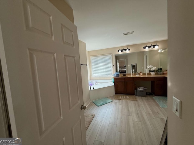 3020 Whitfield Ave, Cumming, GA 30040 - full bathroom with a garden tub, vanity, and wood finished floors
