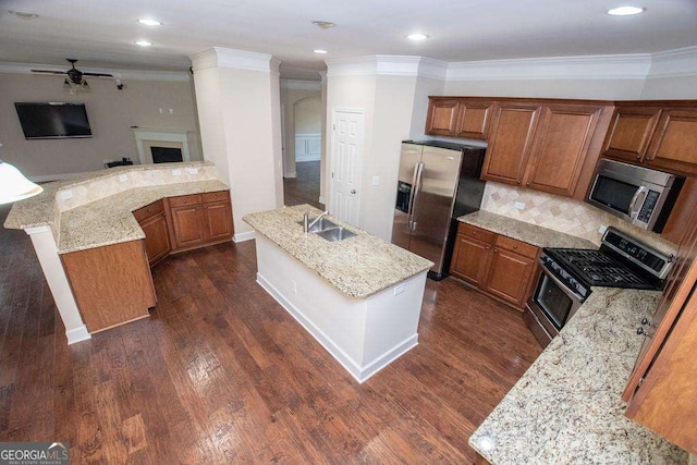 3020 Whitfield Ave, Cumming, GA 30040 - kitchen with stainless steel appliances, a ceiling fan, brown cabinets, ornamental molding, and dark wood-style flooring