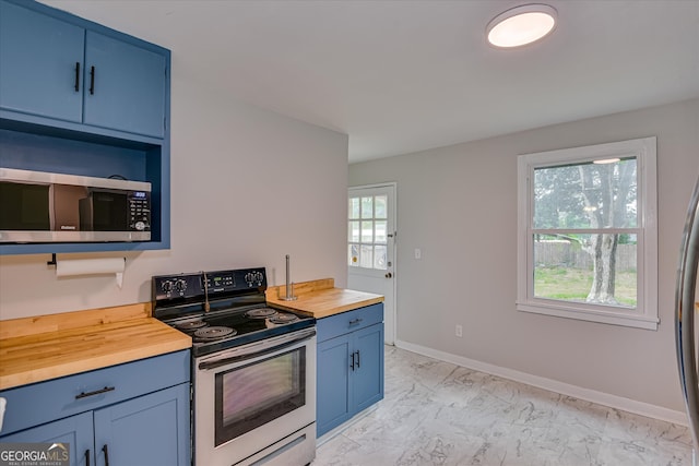 2325 Henry Cir, Augusta, GA 30906 - kitchen featuring butcher block countertops, appliances with stainless steel finishes, blue cabinetry, light marble finish floors, and baseboards