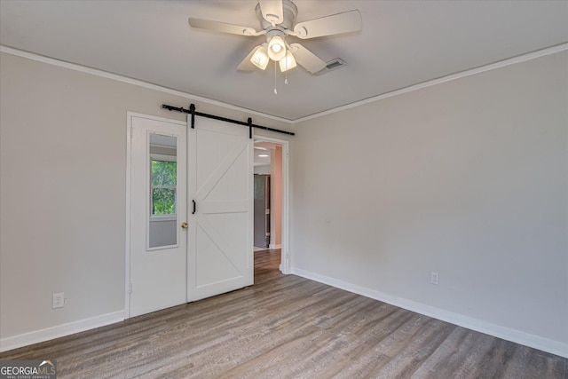 2325 Henry Cir, Augusta, GA 30906 - unfurnished room with wood finished floors, baseboards, crown molding, a ceiling fan, and a barn door