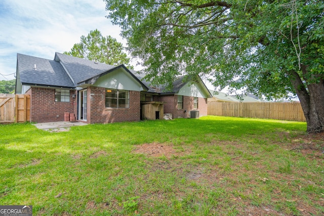 755 Madison Dr, Hinesville, GA 31313 - back of property featuring brick siding, roof with shingles, central AC, and a patio