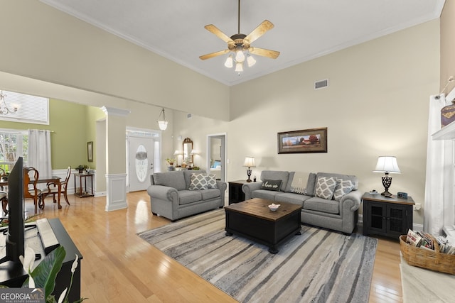 92 Isaiah Dr, Jefferson, GA 30549 - living room with light wood finished floors, ornamental molding, a chandelier, a ceiling fan, and decorative columns