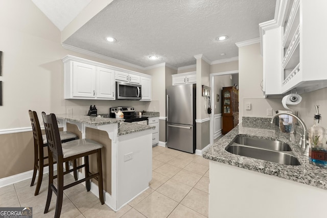 92 Isaiah Dr, Jefferson, GA 30549 - kitchen featuring stainless steel appliances, a sink, a peninsula, light tile patterned floors, and white cabinetry