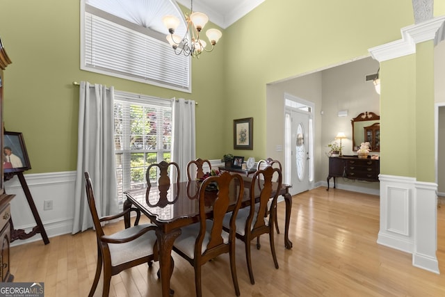 92 Isaiah Dr, Jefferson, GA 30549 - dining space with a towering ceiling, light wood-type flooring, crown molding, a chandelier, and wainscoting