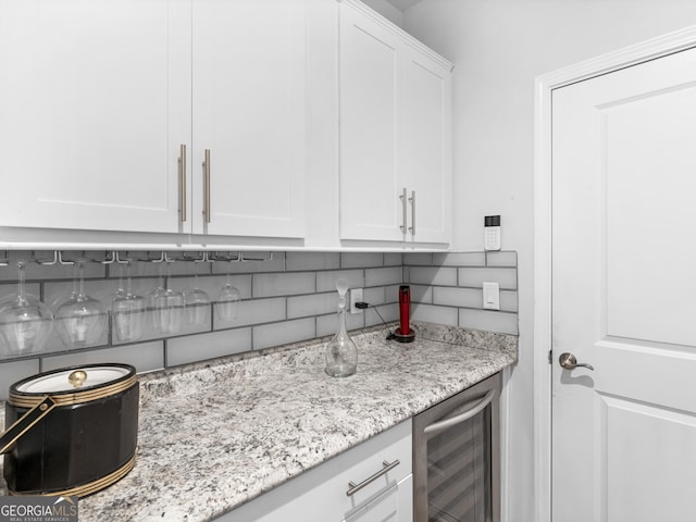 110 Chinkapin Ct, Griffin, GA 30223 - kitchen featuring beverage cooler, tasteful backsplash, white cabinetry, and light stone counters