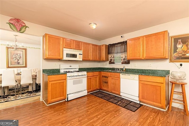 1382 Koble Mill Ln, Riverdale, GA 30296 - kitchen featuring white appliances, a chandelier, dark countertops, and light wood-type flooring