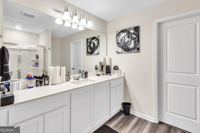 289 Pond Ct, Hoschton, GA 30548 - bathroom featuring vanity, a shower stall, wood finished floors, and baseboards
