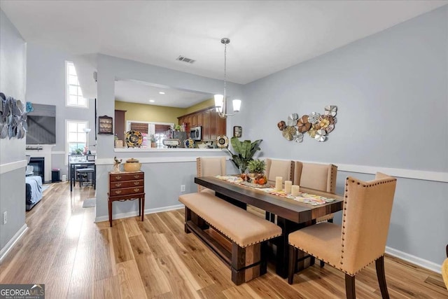 2205 Hoskin Ct NW Unit 9, Kennesaw, GA 30144 - dining room featuring light wood-style flooring, a glass covered fireplace, and a chandelier
