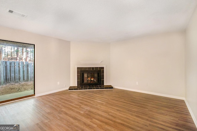 2220 Runnymead Rdg SE, Marietta, GA 30067 - unfurnished living room featuring wood finished floors, baseboards, a fireplace, and a textured ceiling