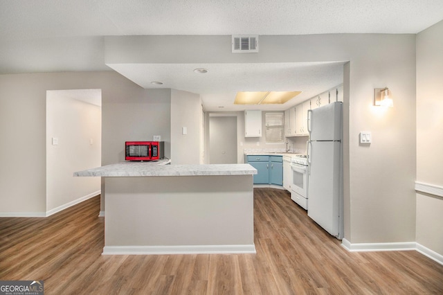 2220 Runnymead Rdg SE, Marietta, GA 30067 - kitchen with white appliances, light countertops, baseboards, and wood finished floors