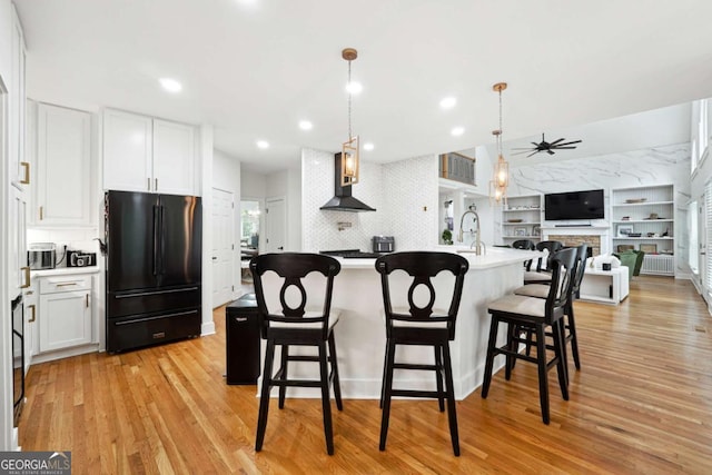 5535 Buck Hollow Dr, Alpharetta, GA 30005 - kitchen featuring freestanding refrigerator, light wood-style floors, a ceiling fan, white cabinetry, and a kitchen breakfast bar